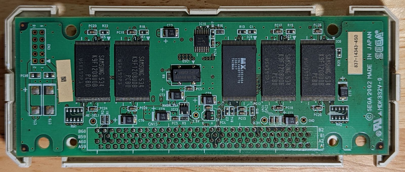 Photo of Triforce Type 3 NAND cartridge interior, top view. Four Samsung 64M flash memory chips are visible on top, among other chips.