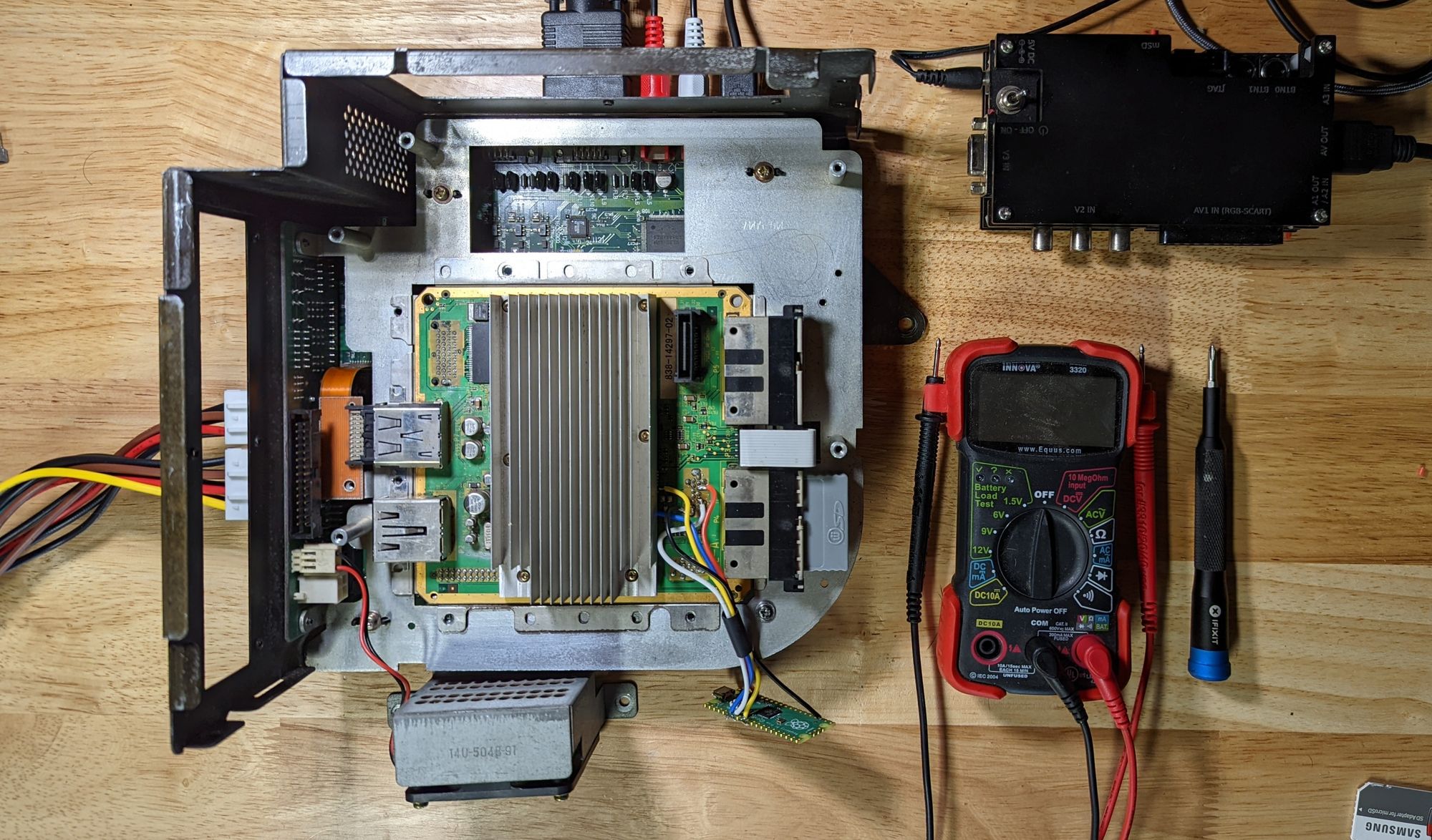 A Triforce arcade unit stripped down to the main board component, showing an installed Picoboot mod.